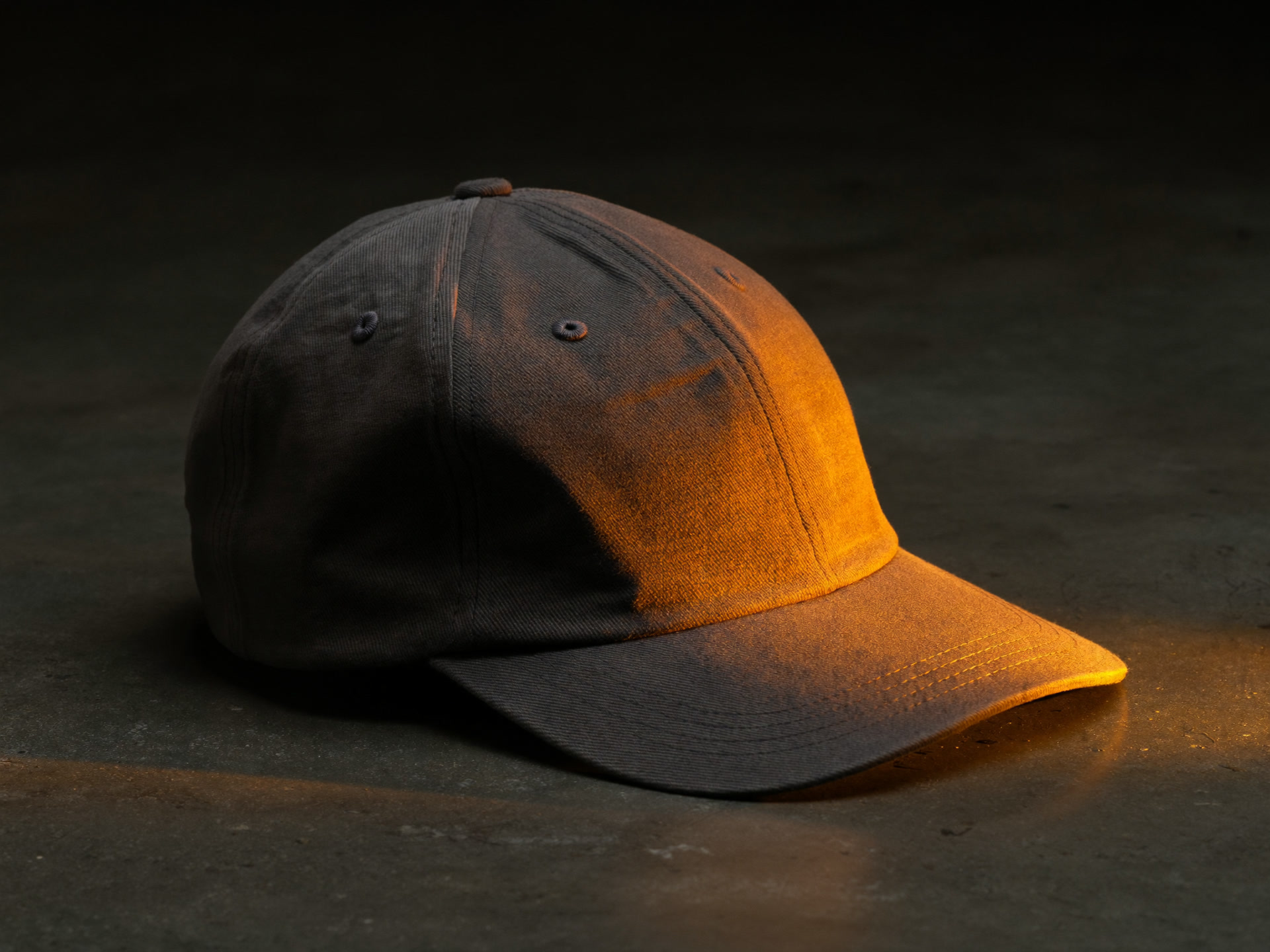 Unstructured washed charcoal six panel cap on dark concrete